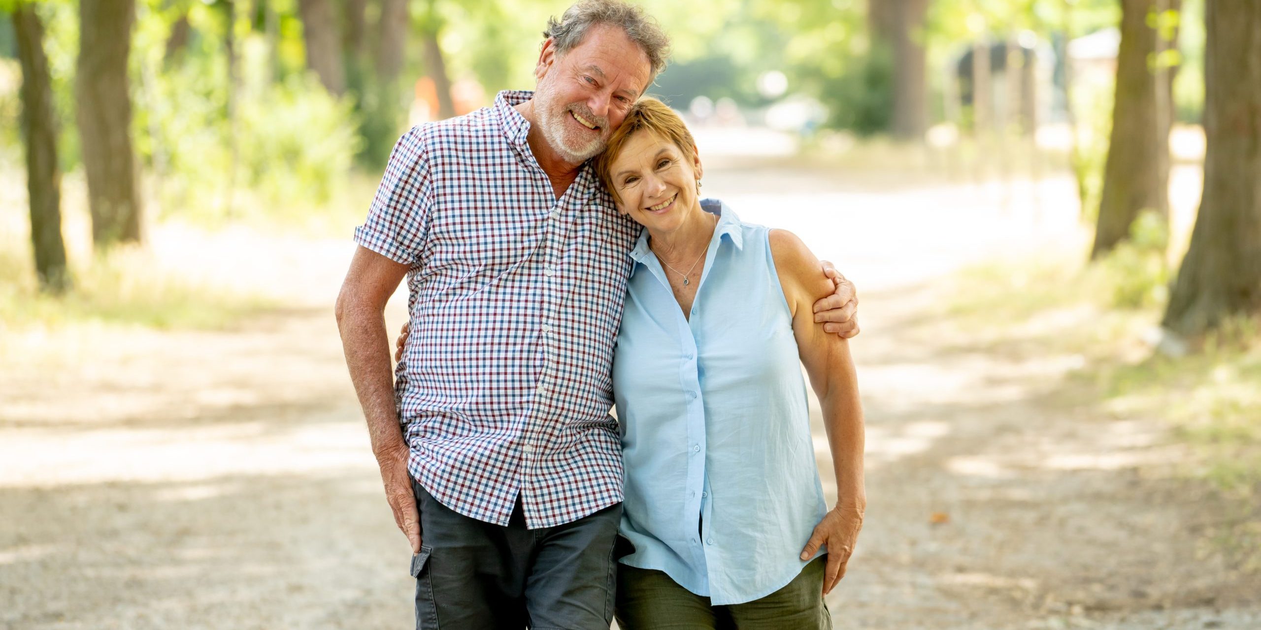 Happy beautiful senior couple in love walking and holding hands in the park enjoying life outdoors. Happy and active retirement concept