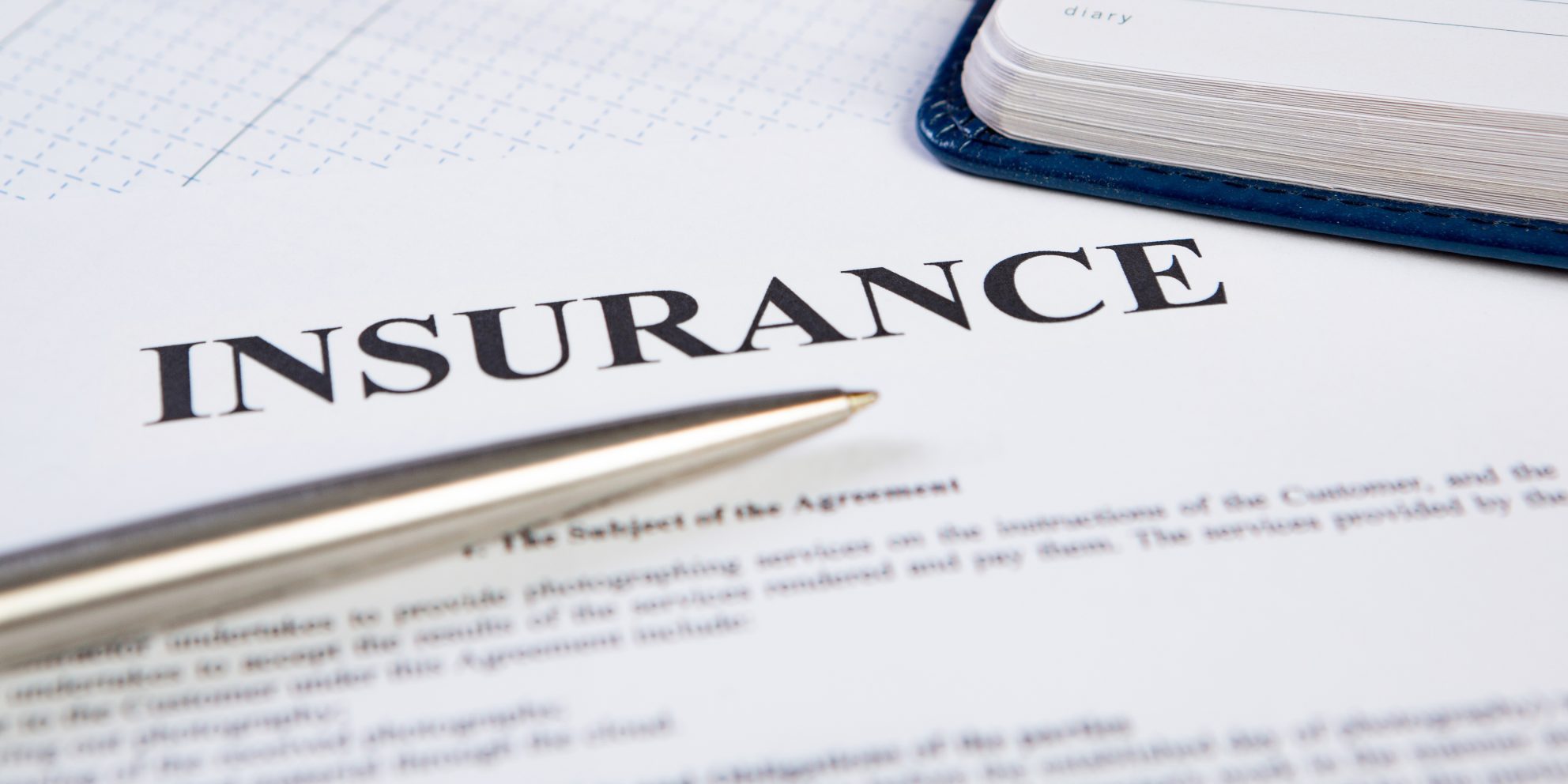 Closeup the silver ballpoint modern pen on insurance contract with planning in background. Closeup the silver ballpoint modern pen on insurance contract with planning in background.