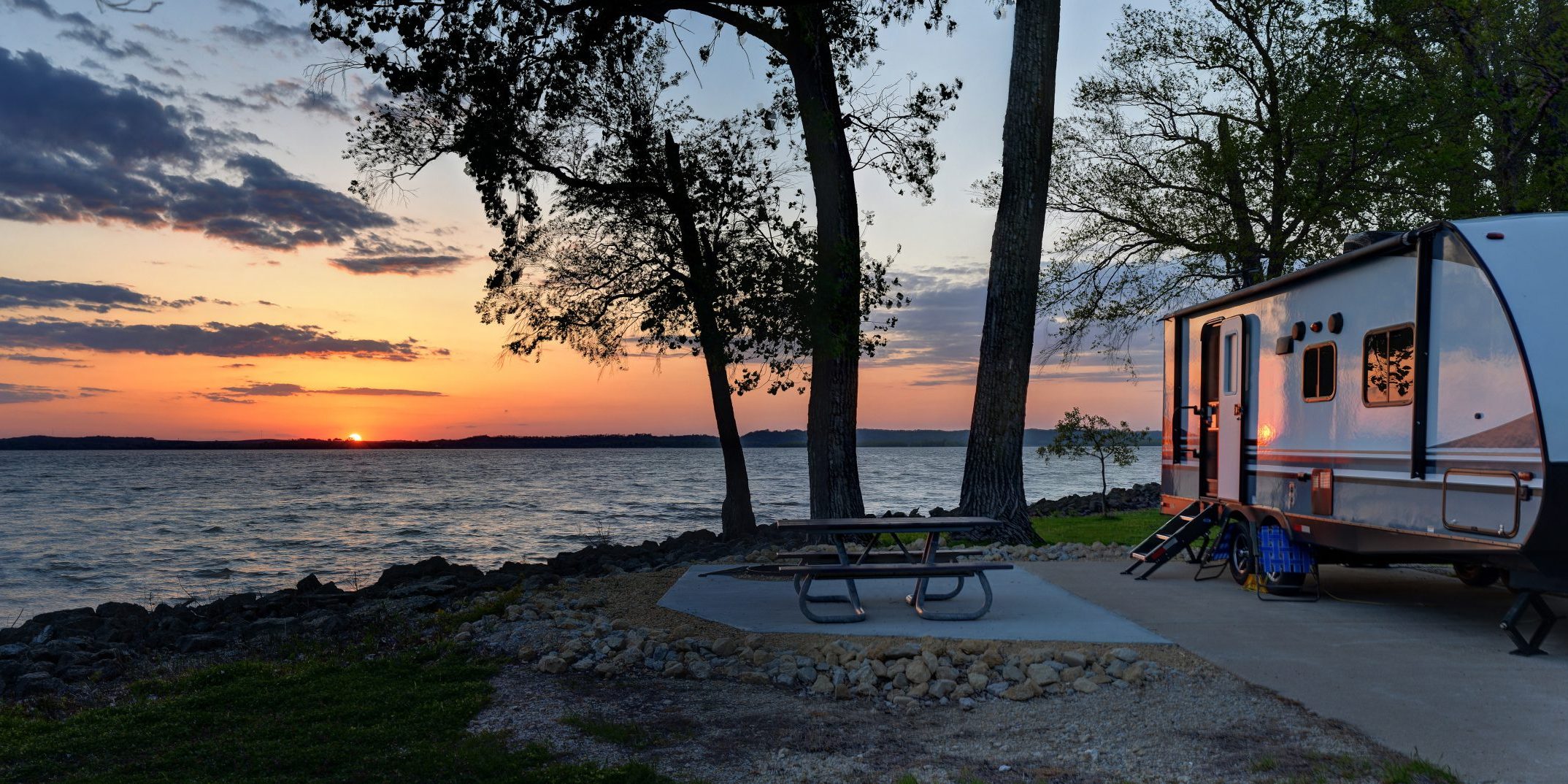 Travel trailer camping at sunset by the Mississippi river in Illinois at sunset panorama